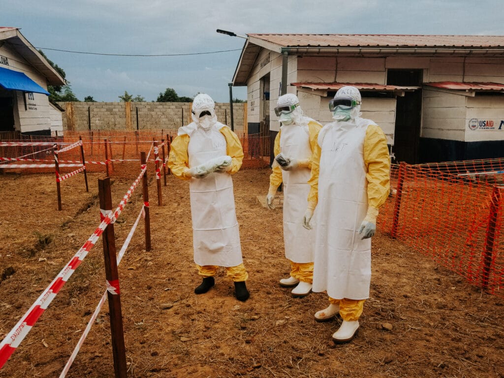 Tre personer påkledd beskyttelsesutstyr mot ebola.